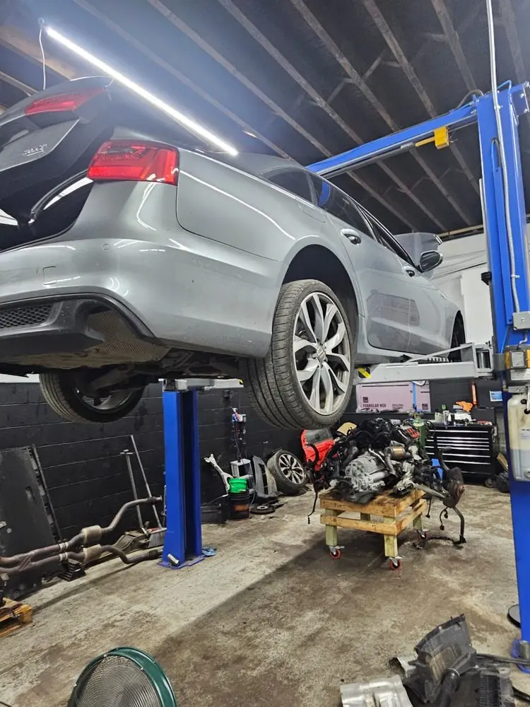 Sedan on a lift with its engine removed beneath